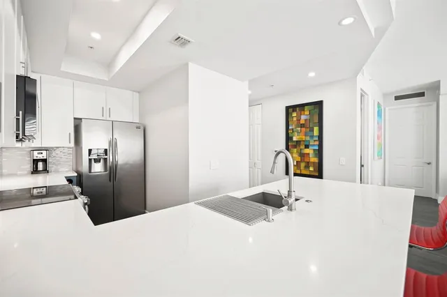 a kitchen with stainless steel appliances kitchen island a refrigerator sink and stove