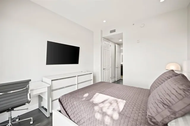 a bedroom with a bed and a flat screen tv