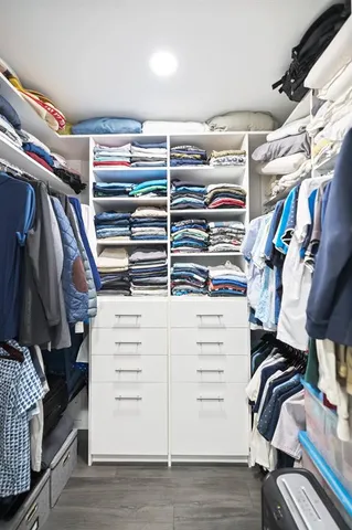 a view of walk in closet with clothes and shoes