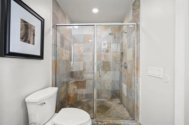 a bathroom with a toilet and a shower