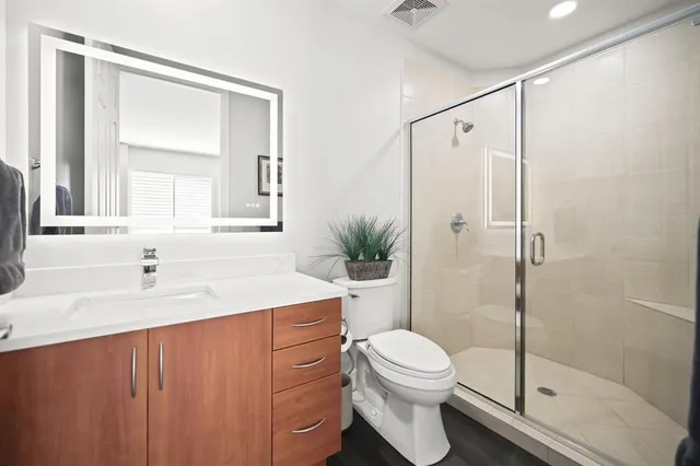 a bathroom with a sink a toilet and shower