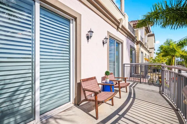 a balcony with chairs and with potted plants