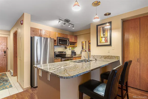 a kitchen with granite countertop cabinets and refrigerator