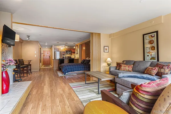 a living room with furniture and a wooden floor