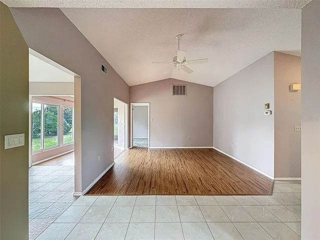 a view of a room with wooden floor chandelier and a window