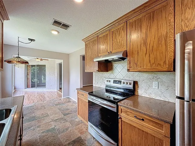 a kitchen with stainless steel appliances a sink stove and cabinets
