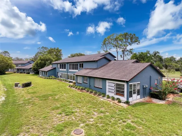 a view of a house with pool and a yard