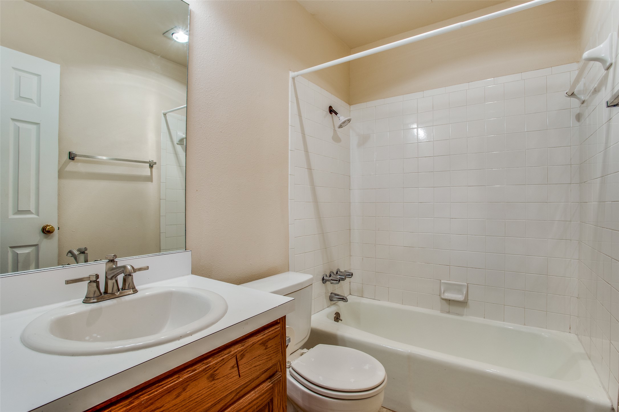 8811 Clearbrook Trail Austin, TX 78729 - Photo 28 of 38 rt B - A well-appointed bathroom features a single vanity, a standard toilet, and a combination tub and shower tiled for easy maintenance.