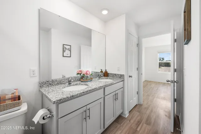 a bathroom with a granite countertop sink and a mirror