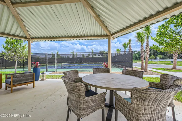 a view of a patio with a table chairs and a backyard