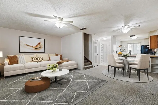 a living room with furniture kitchen view and a chandelier
