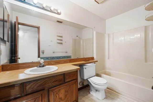 a bathroom with a granite countertop toilet sink and mirror