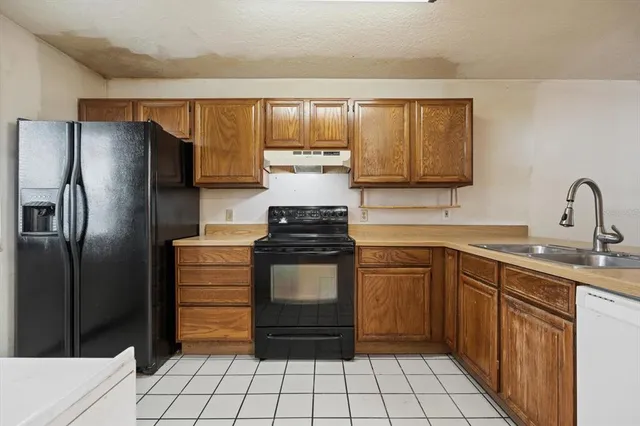 a kitchen with a refrigerator sink and cabinets