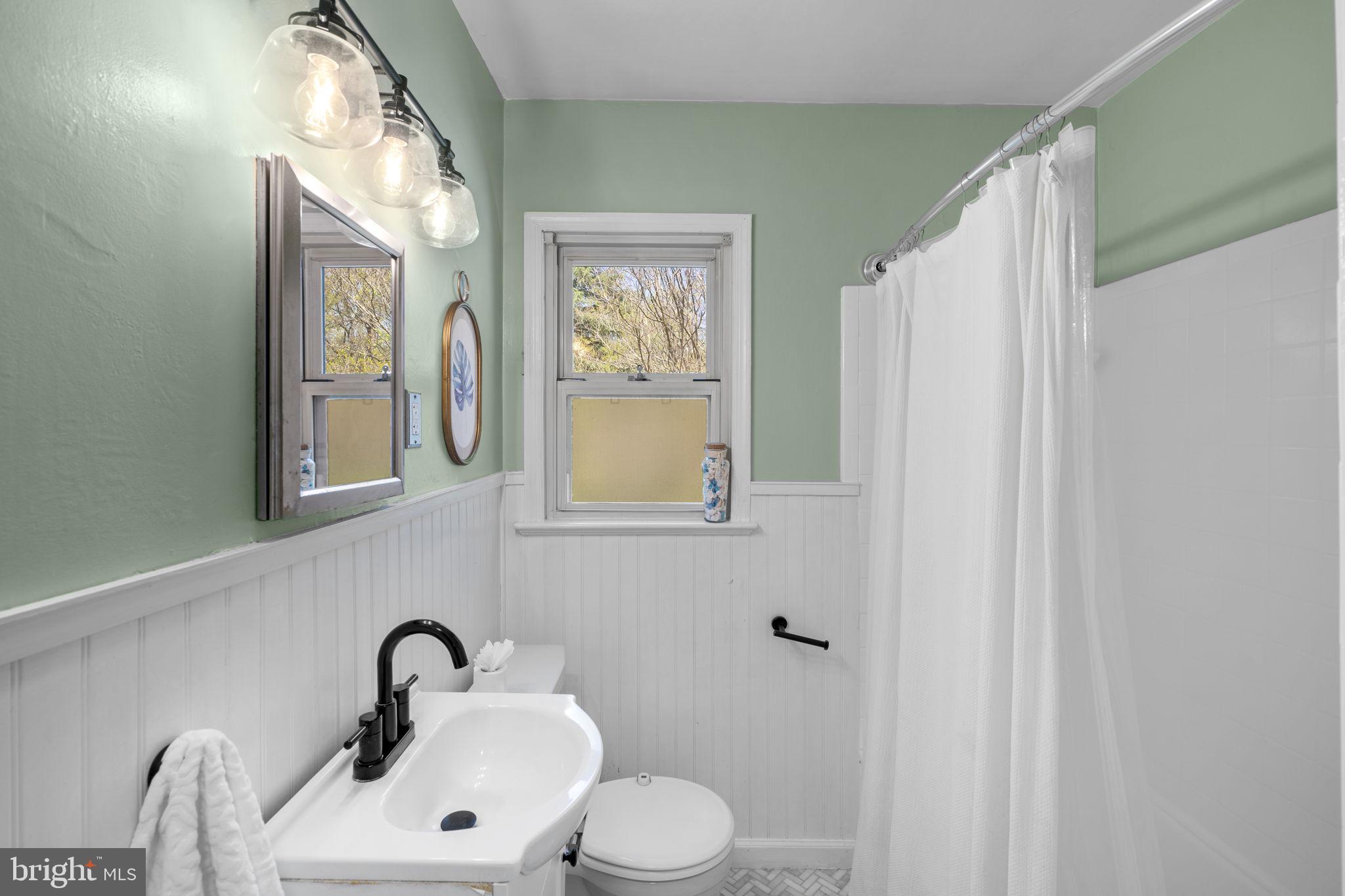 7005 Grove Road Alexandria, VA 22306 - Photo 32 of 52 a bathroom with a toilet sink and mirror