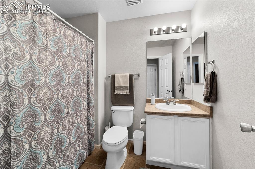 7375 Sandy Springs Point Fountain, CO 80817 - Photo 12 of 31 a bathroom with a granite countertop sink toilet and mirror