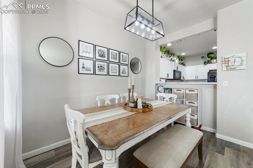 7375 Sandy Springs Point Fountain, CO 80817 - Photo 22 of 31 a dining room with wooden floor and chandelier