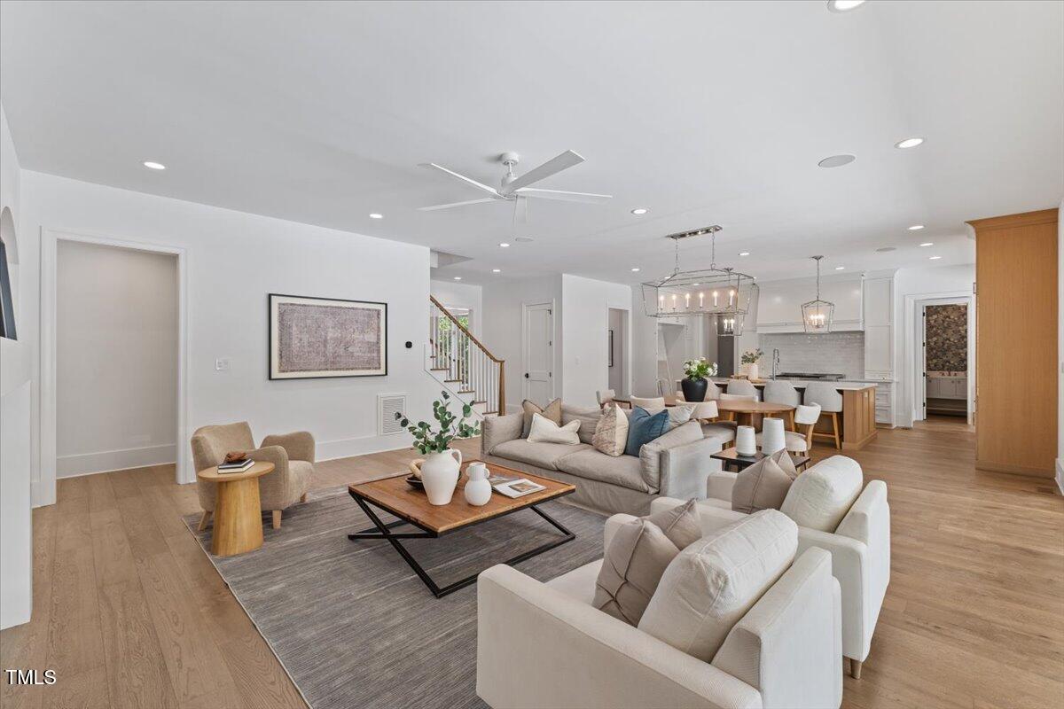 6844 Greystone Drive Raleigh, NC 27615 - Photo 21 of 83 a living room with furniture kitchen view and a wooden floor