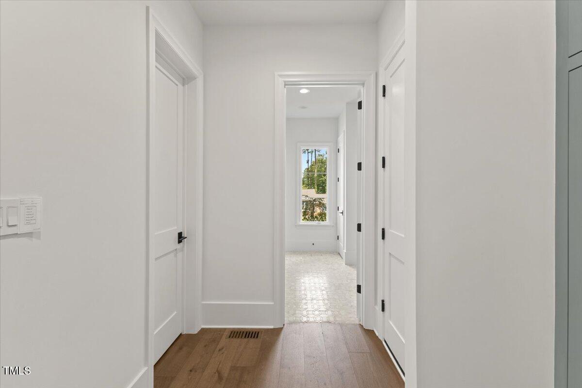 6844 Greystone Drive Raleigh, NC 27615 - Photo 28 of 83 a view of a hallway with wooden floor and tub