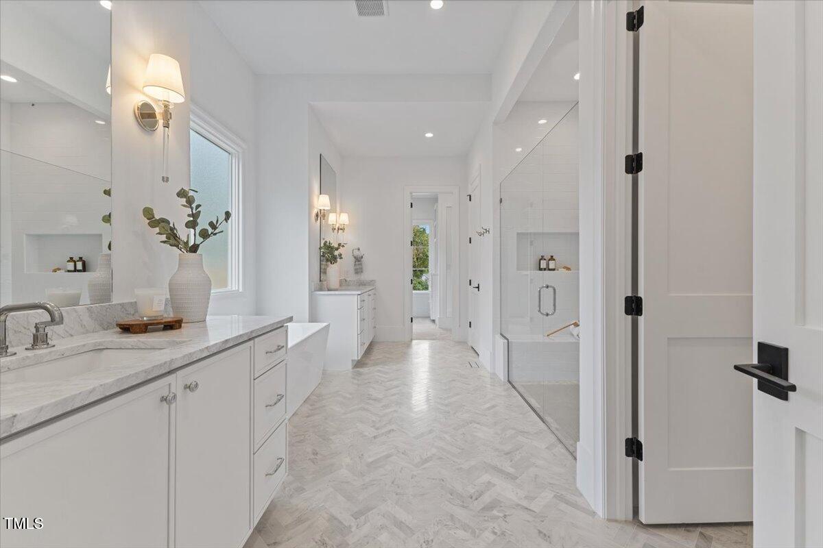 6844 Greystone Drive Raleigh, NC 27615 - Photo 34 of 83 a spacious bathroom with a granite countertop sink a mirror and a shower