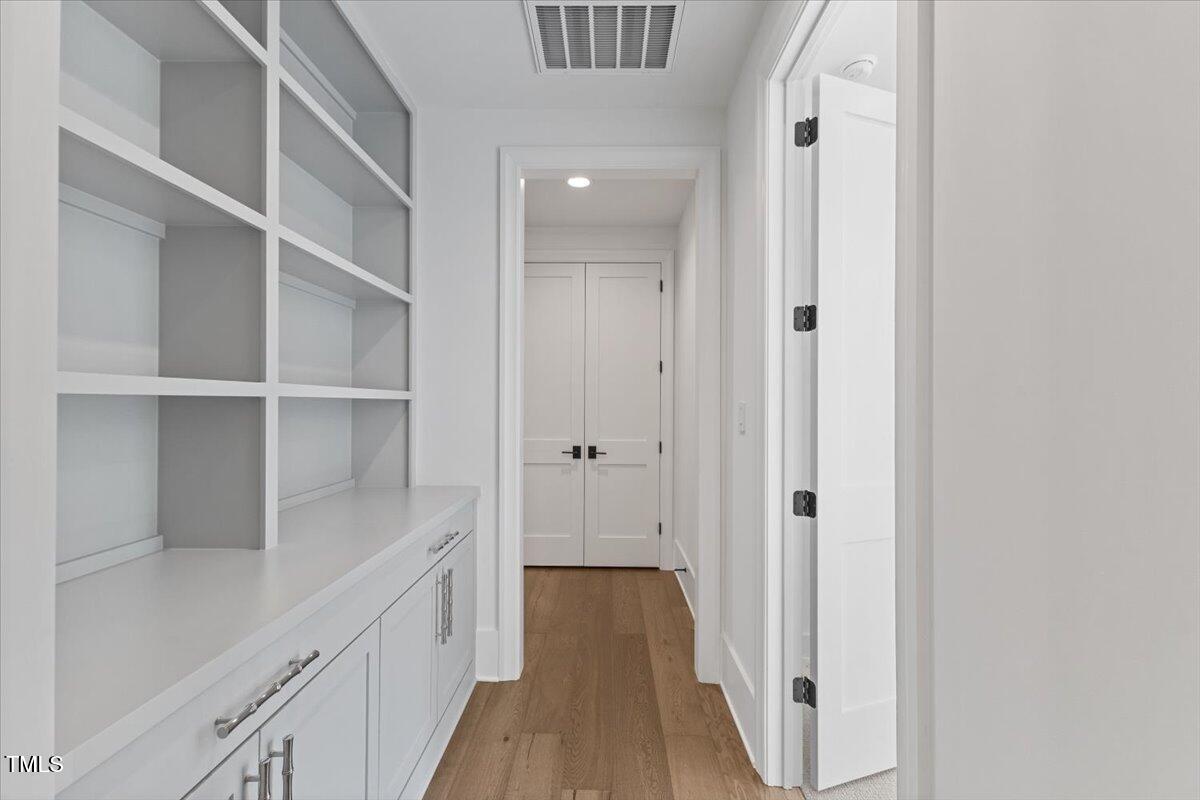 6844 Greystone Drive Raleigh, NC 27615 - Photo 53 of 83 a view of a hallway with wooden floor and staircase