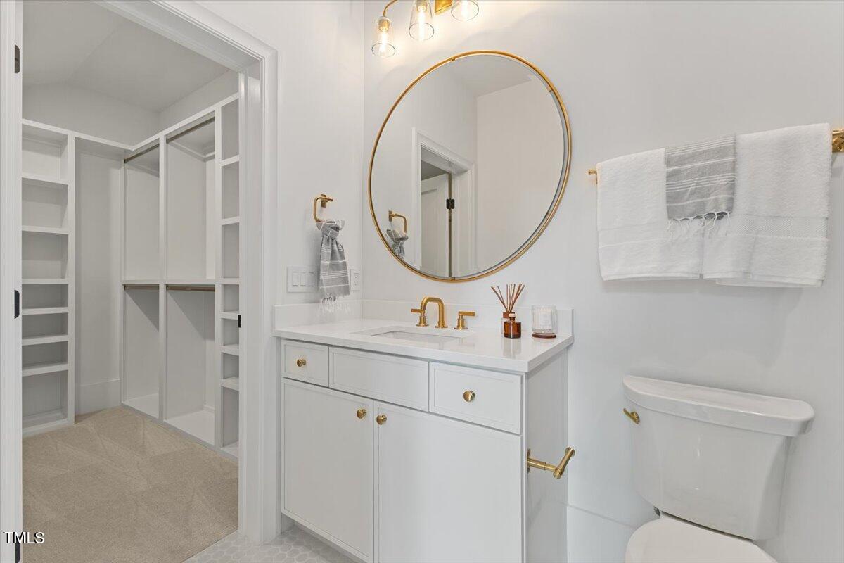 6844 Greystone Drive Raleigh, NC 27615 - Photo 60 of 83 a bathroom with a sink a toilet and a mirror
