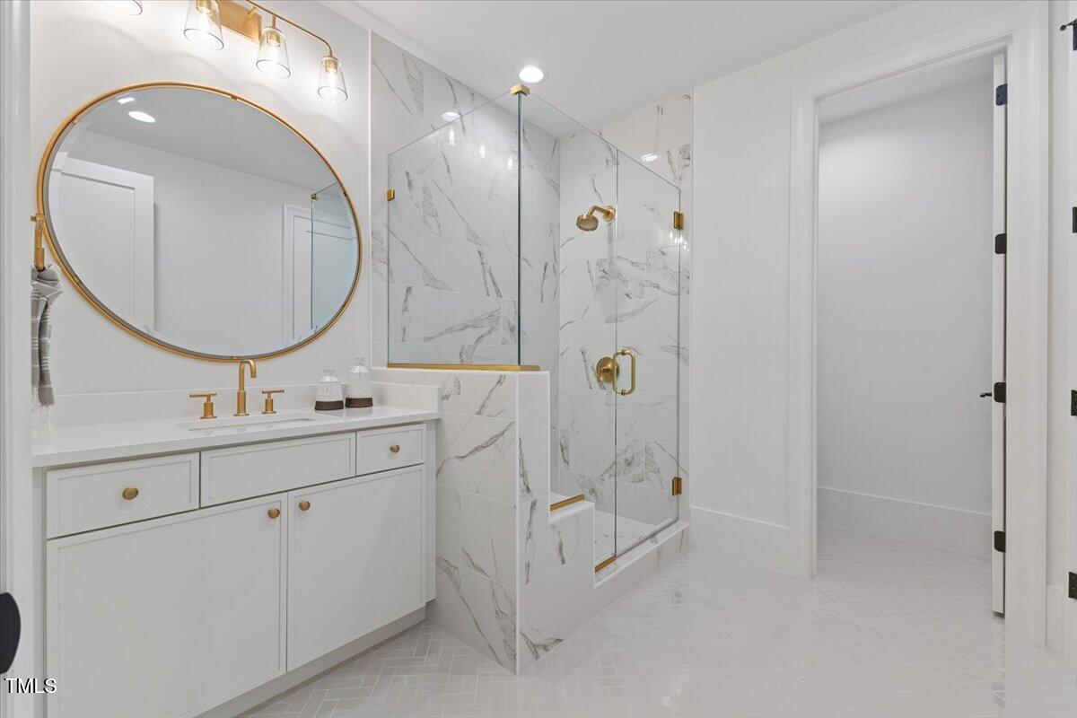 6844 Greystone Drive Raleigh, NC 27615 - Photo 65 of 83 a bathroom with a double vanity sink mirror and shower