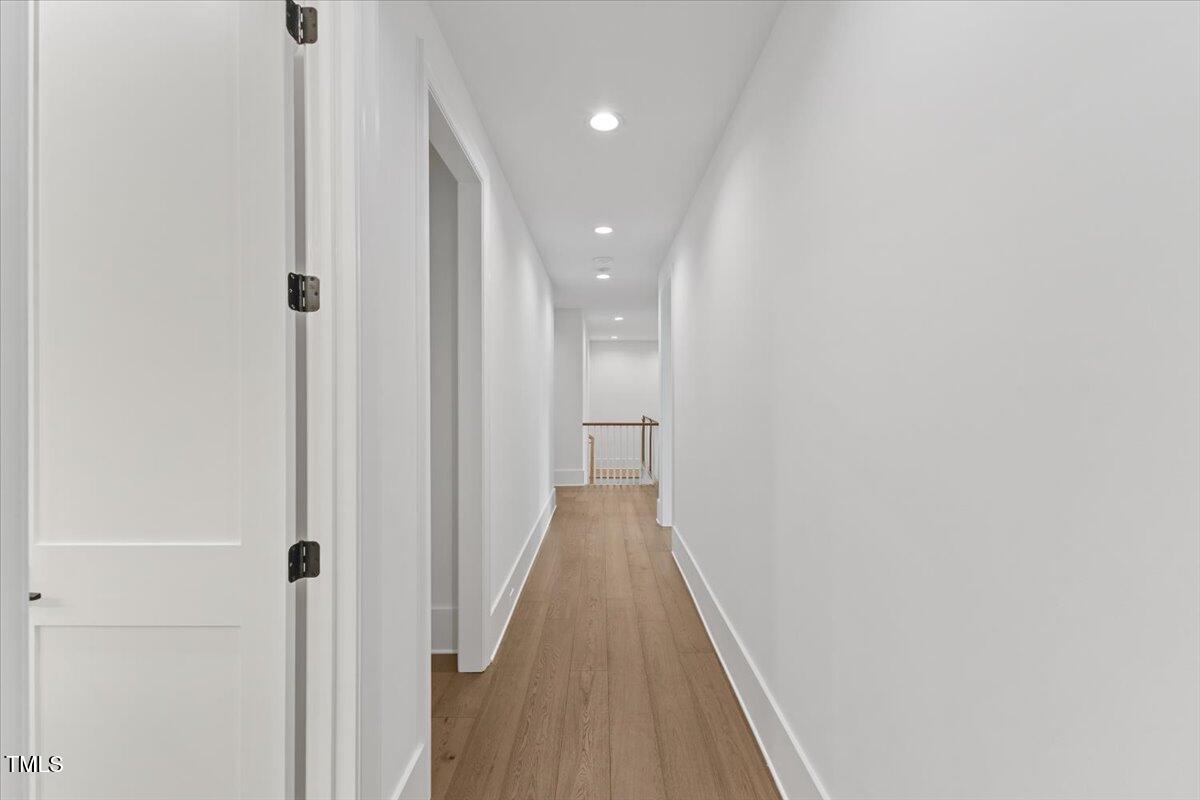 6844 Greystone Drive Raleigh, NC 27615 - Photo 72 of 83 a view of a hallway with wooden floor and a bathroom