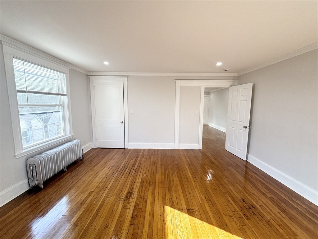 36 Spring Street, Unit 11 Malden, MA 02148 - Photo 7 of 12 a view of an empty room with wooden floor and window