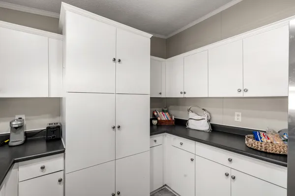 a kitchen with stainless steel appliances granite countertop white cabinets sink and a refrigerator