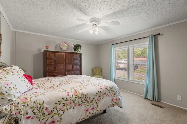a bedroom with a bed and a large window
