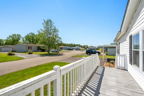 a view of a house with wooden deck and furniture