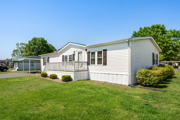 a view of a house with a yard and deck
