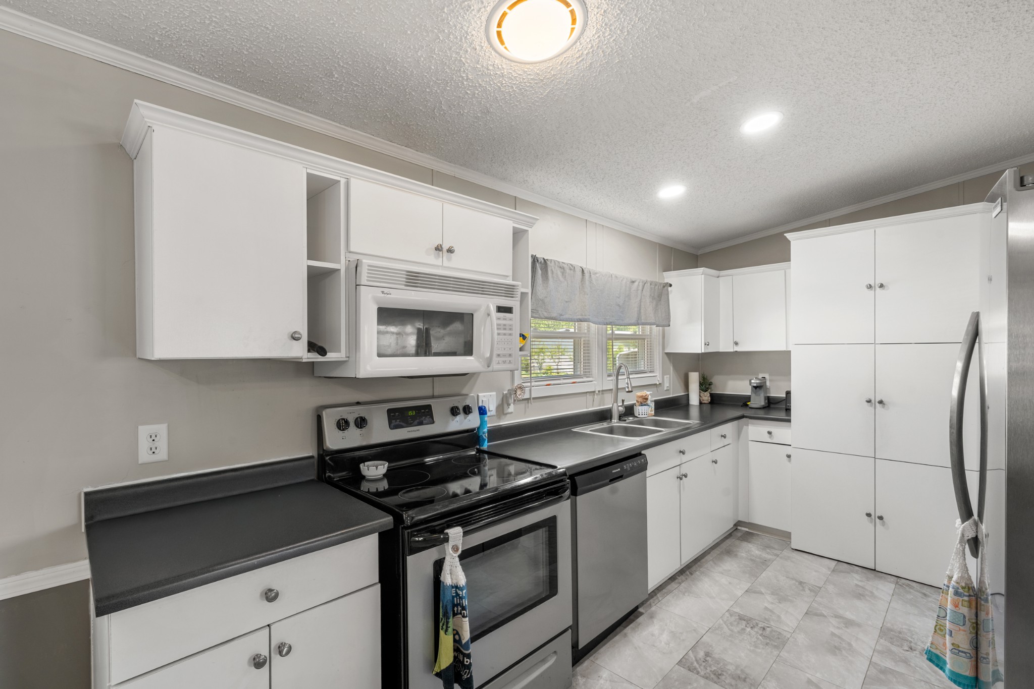 129 Broken Arrow Paris, TN 38242 - Photo 7 of 49 a kitchen with stainless steel appliances granite countertop a sink stove refrigerator and cabinets