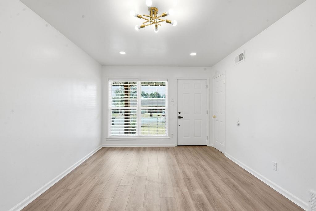 1304 Winfield Road Memphis, TN 38116 - Photo 5 of 19 Recessed lighting, wood-finish flooring, paneled entry door, window with blinds, and a Sputnik-style ceiling fixture