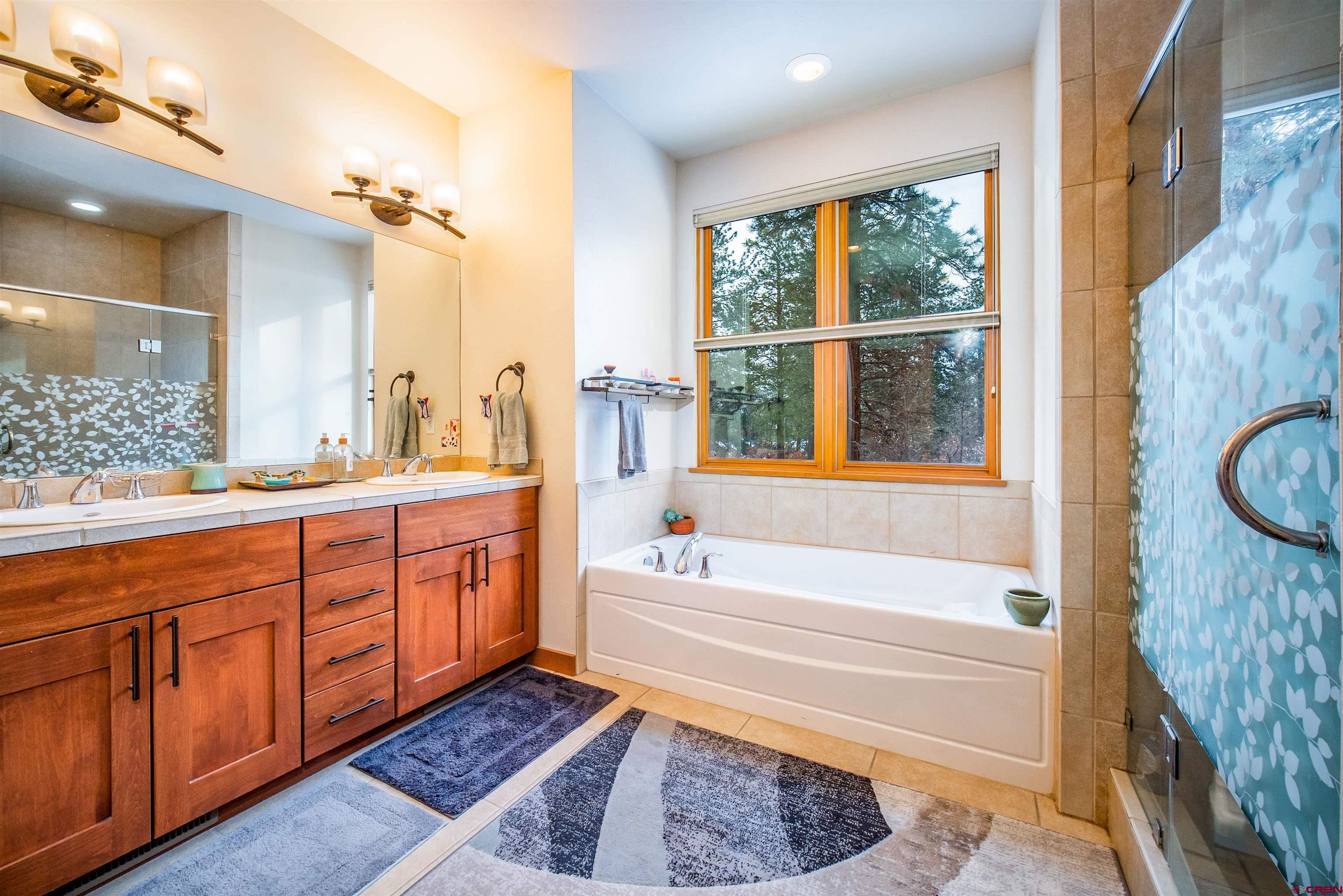 25 Red Table Court Durango, CO 81301 - Photo 12 of 34 a bathroom with a tub a sink and a large window