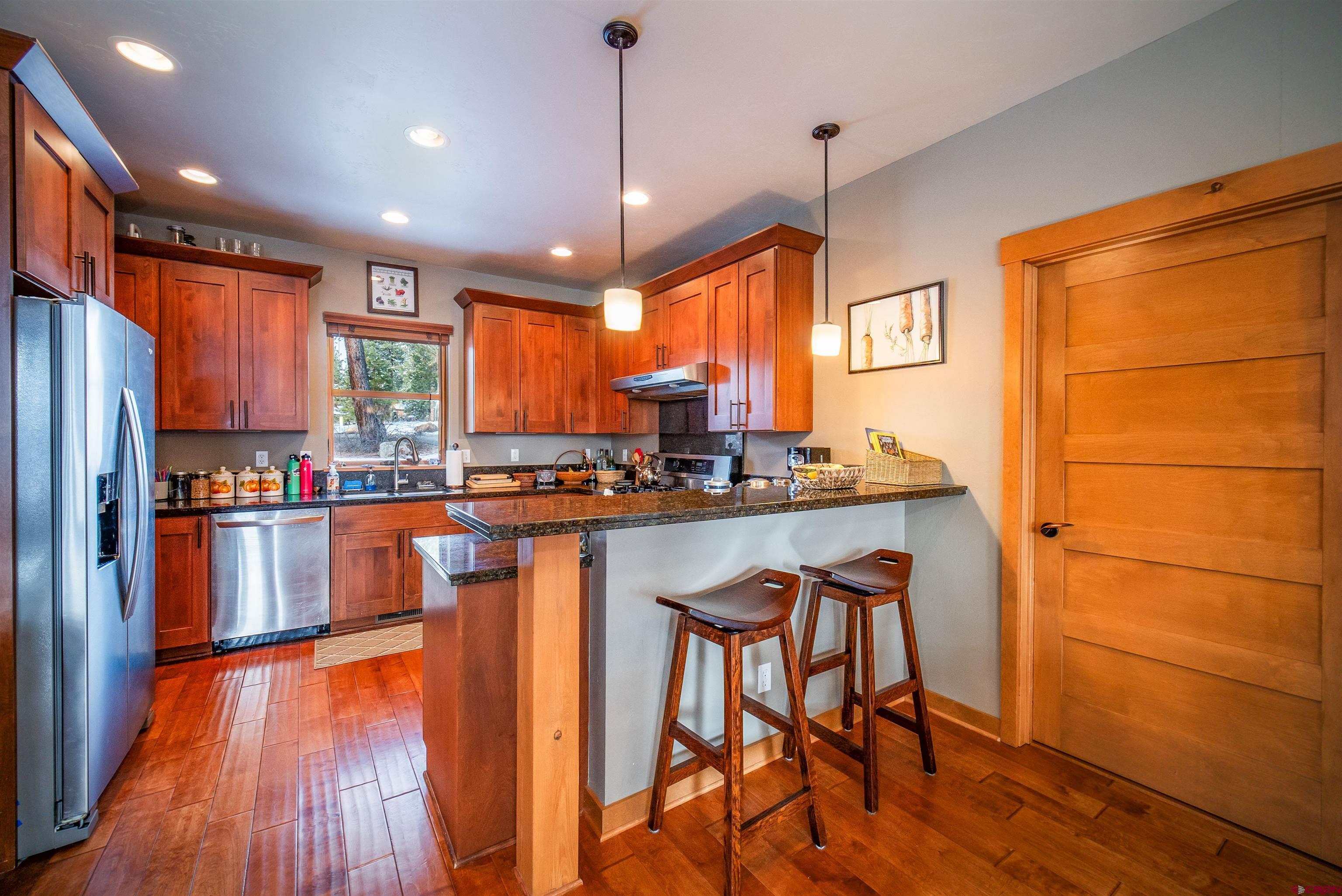 25 Red Table Court Durango, CO 81301 - Photo 9 of 34 a kitchen with stainless steel appliances granite countertop wooden floors refrigerator and window