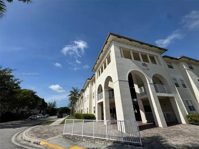 a front view of a multi story building with yard