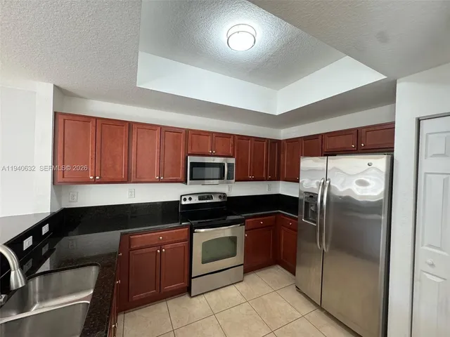 a kitchen with a refrigerator sink and cabinets