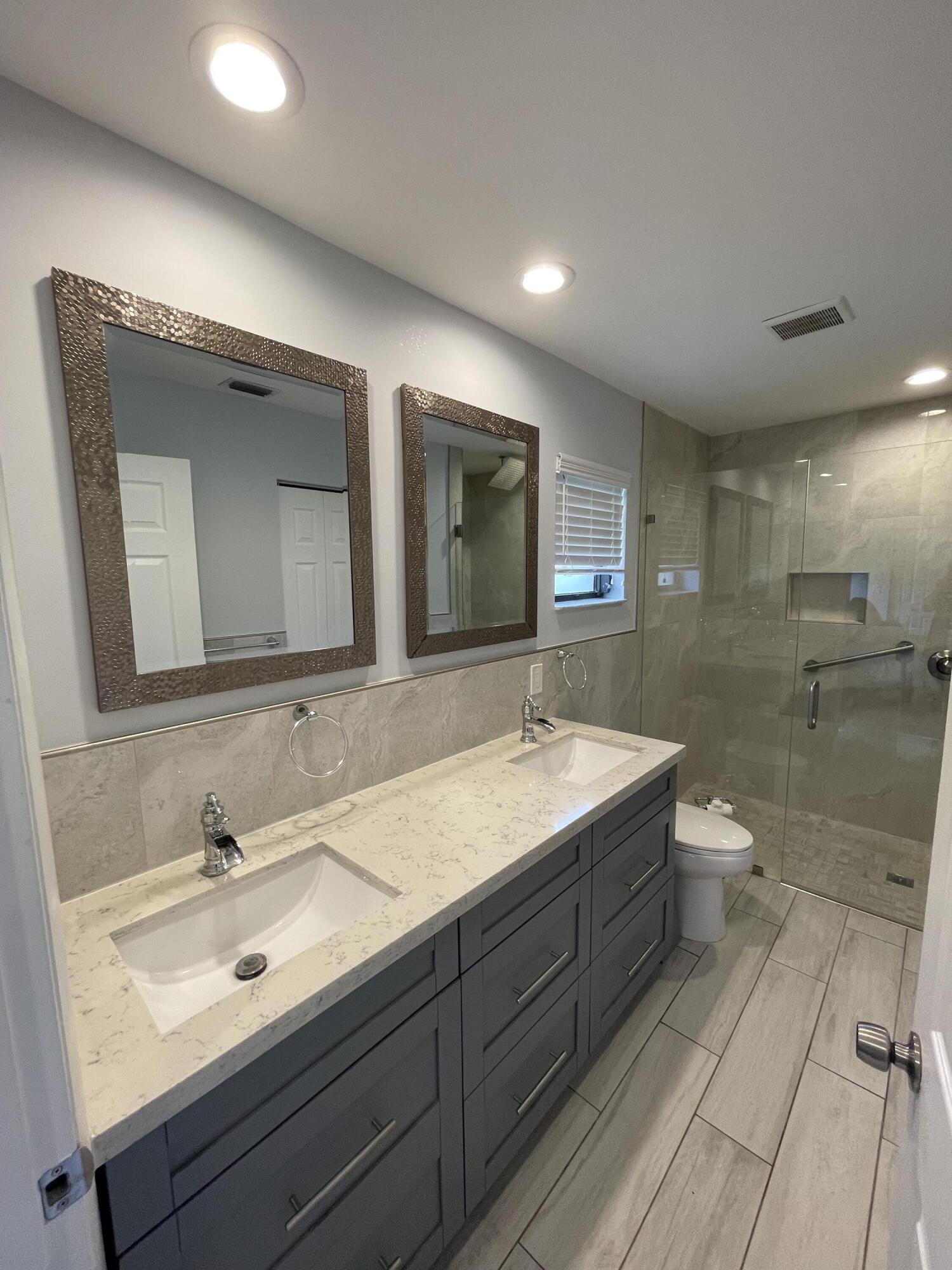 6157 Sunny Pointe Circle Delray Beach, FL 33484 - Photo 15 of 64 a bathroom with a double vanity sink and a mirror