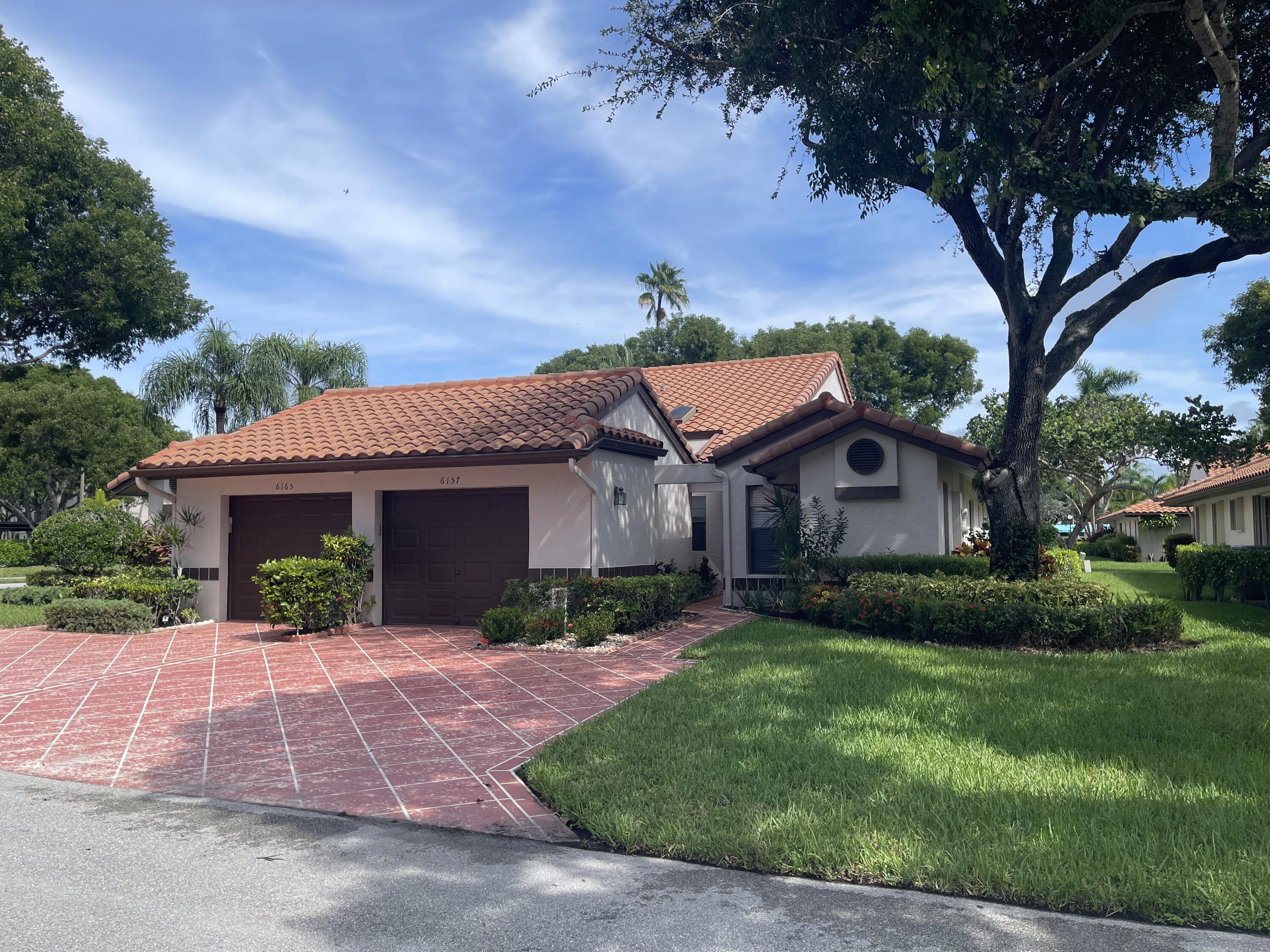 6157 Sunny Pointe Circle Delray Beach, FL 33484 - Photo 2 of 64 a front view of a house with garden