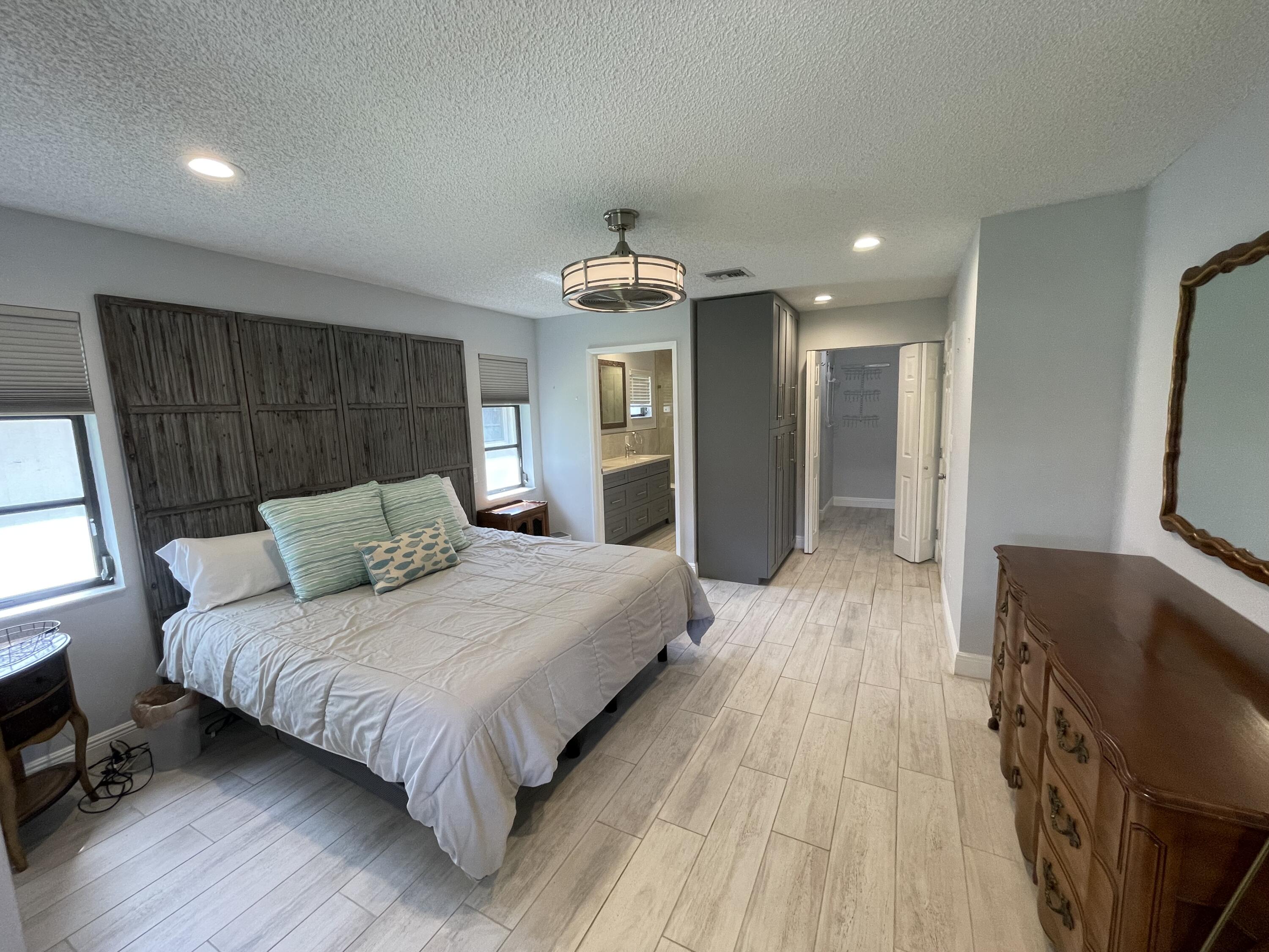 6157 Sunny Pointe Circle Delray Beach, FL 33484 - Photo 21 of 64 a bedroom with a bed and a flat tv screen on dresser