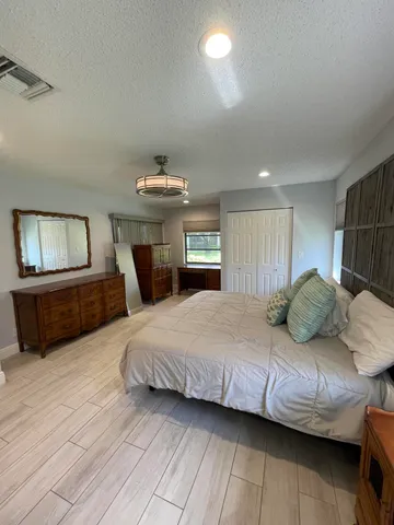 a spacious bedroom with a bed and wooden floor