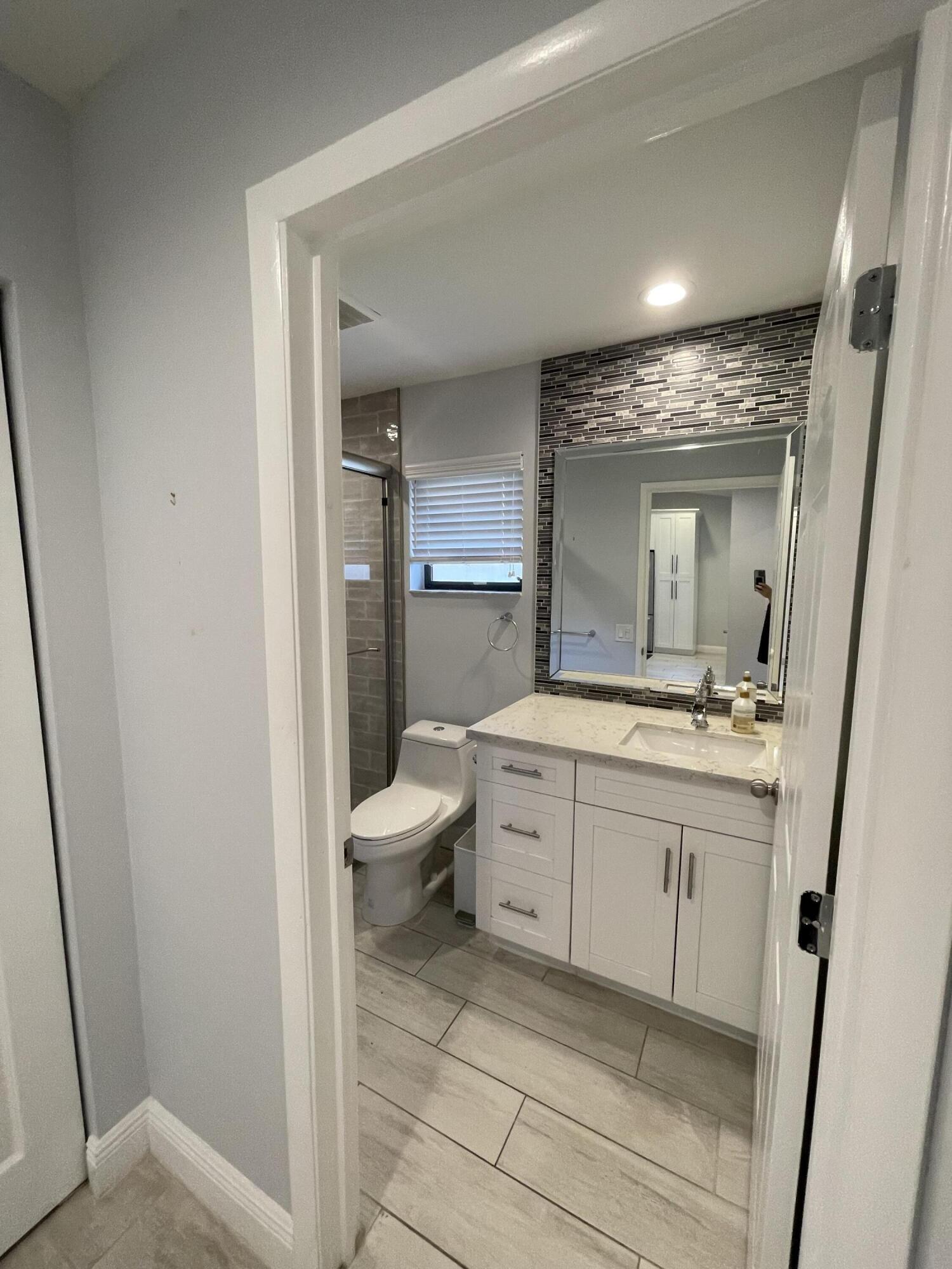 6157 Sunny Pointe Circle Delray Beach, FL 33484 - Photo 27 of 64 a spacious bathroom with a bathtub sink mirror and toilet