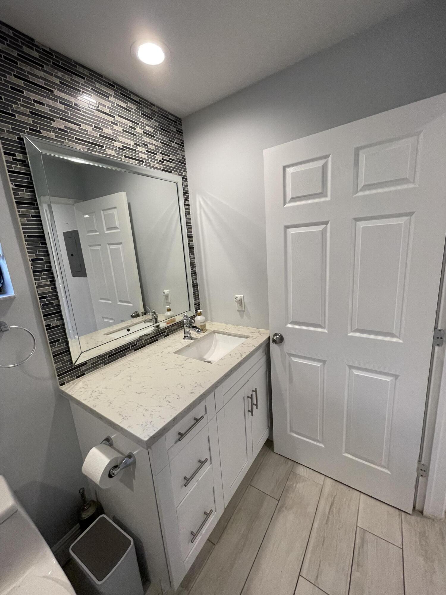 6157 Sunny Pointe Circle Delray Beach, FL 33484 - Photo 28 of 64 a bathroom with a granite countertop sink and a mirror
