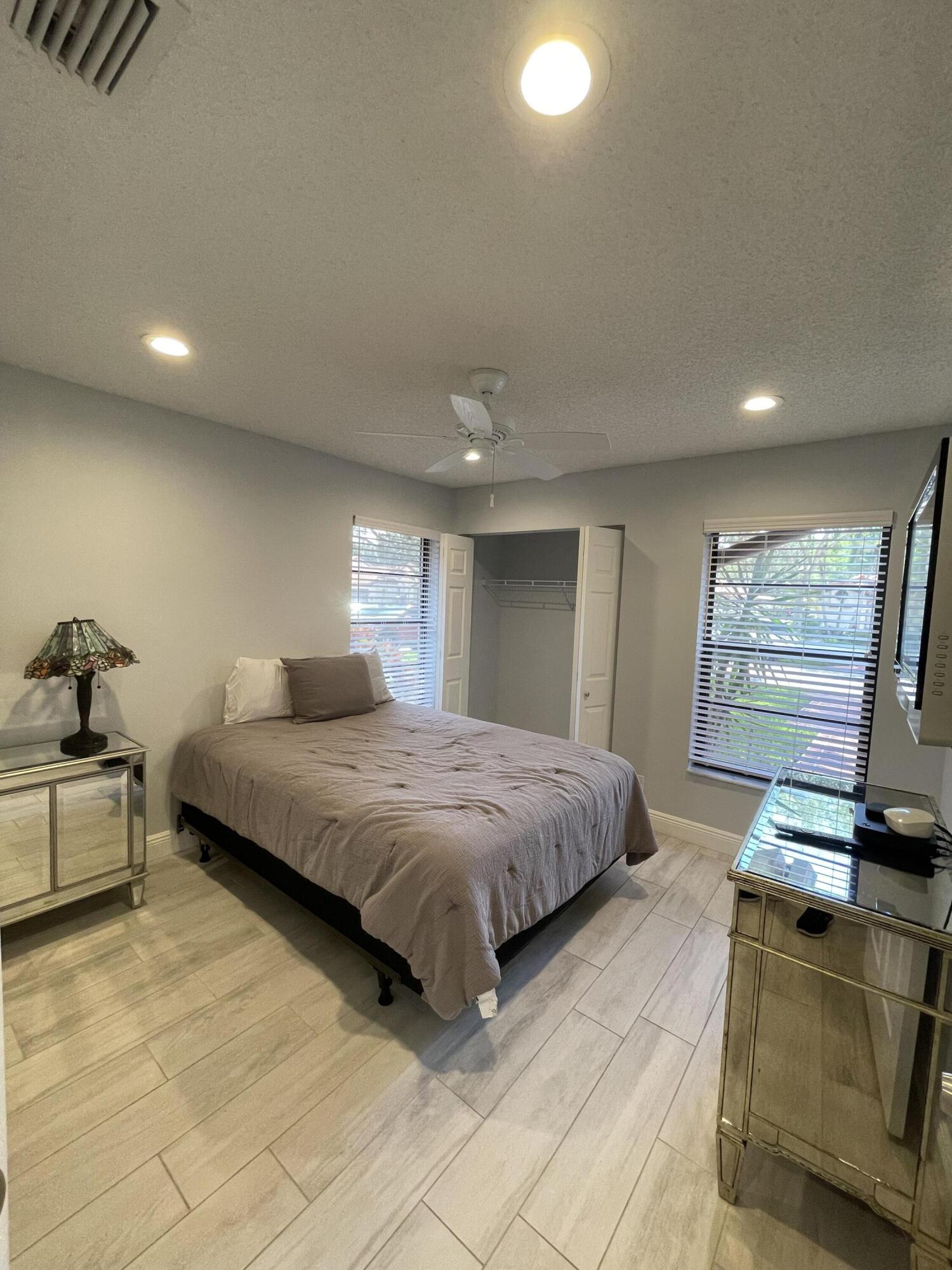 6157 Sunny Pointe Circle Delray Beach, FL 33484 - Photo 29 of 64 a spacious bedroom with a bed and wooden floor