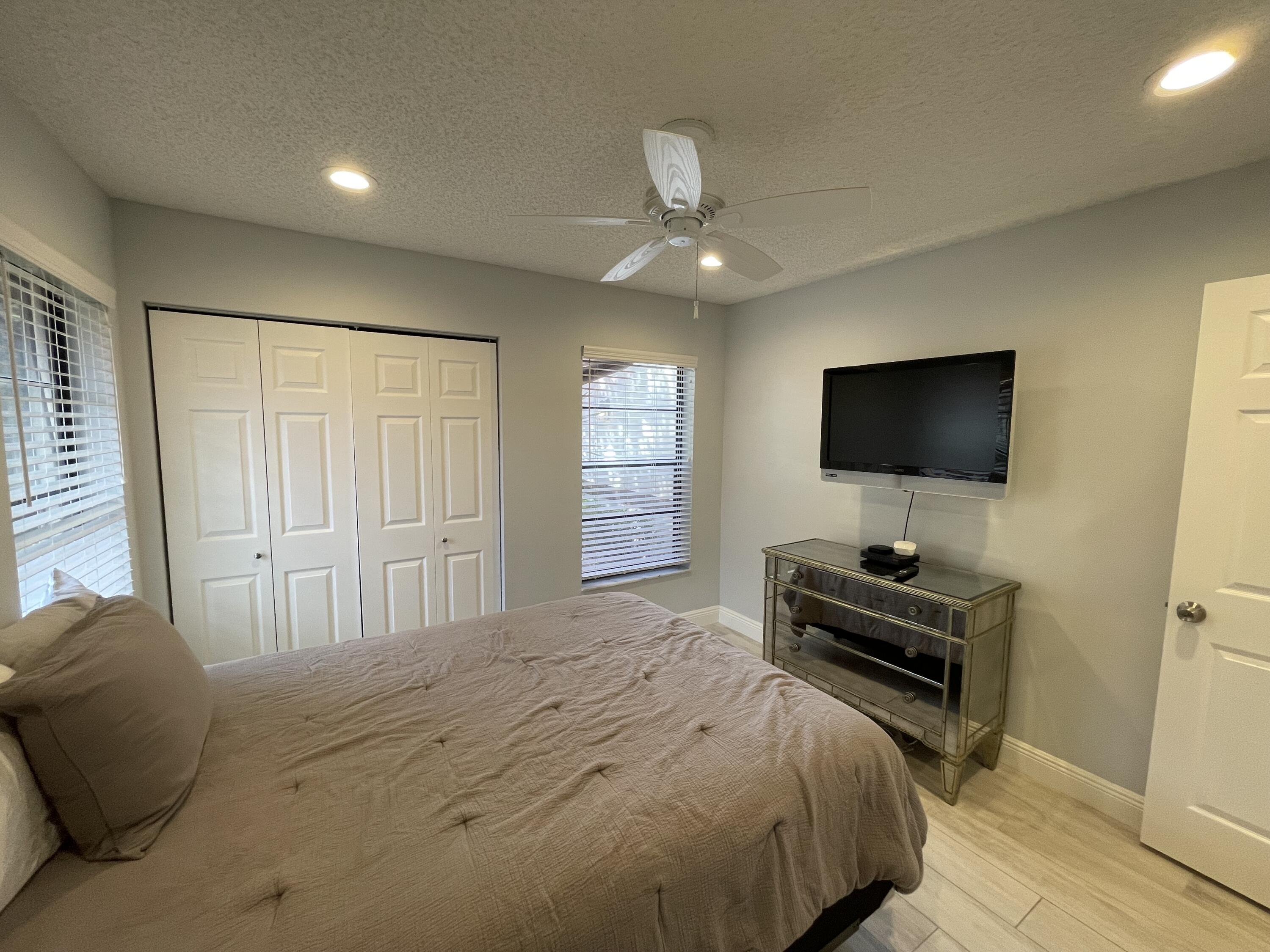 6157 Sunny Pointe Circle Delray Beach, FL 33484 - Photo 30 of 64 a bedroom with a bed and a flat screen tv