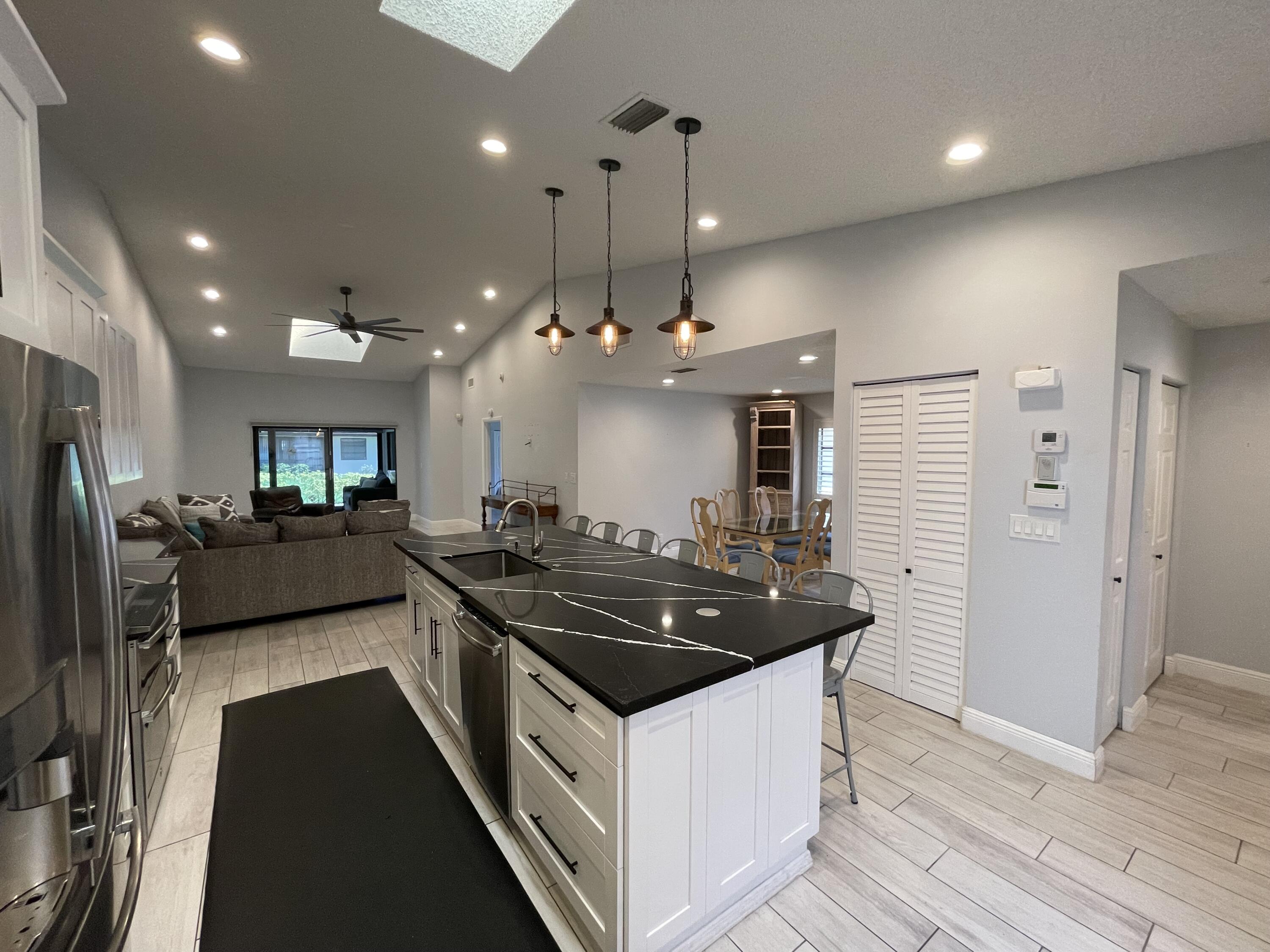 6157 Sunny Pointe Circle Delray Beach, FL 33484 - Photo 3 of 64 a kitchen with stainless steel appliances granite countertop a stove a sink a refrigerator and a oven with wooden floor