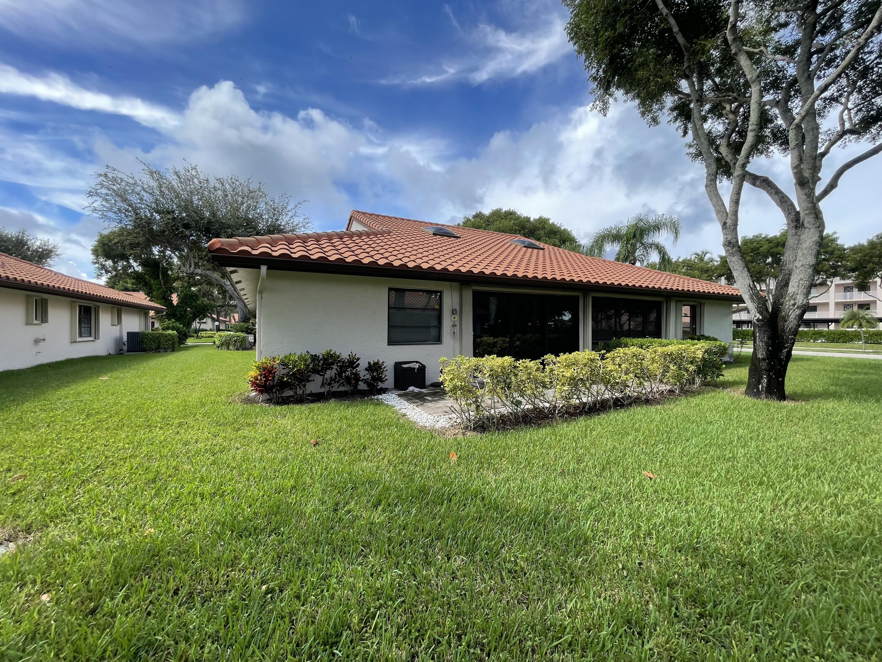 6157 Sunny Pointe Circle Delray Beach, FL 33484 - Photo 36 of 64 a view of a house with backyard sitting area and garden