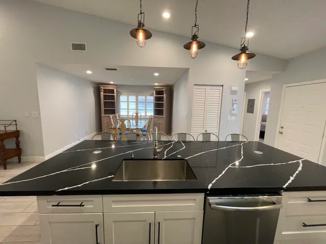 a kitchen with stainless steel appliances granite countertop a sink a stove and a refrigerator