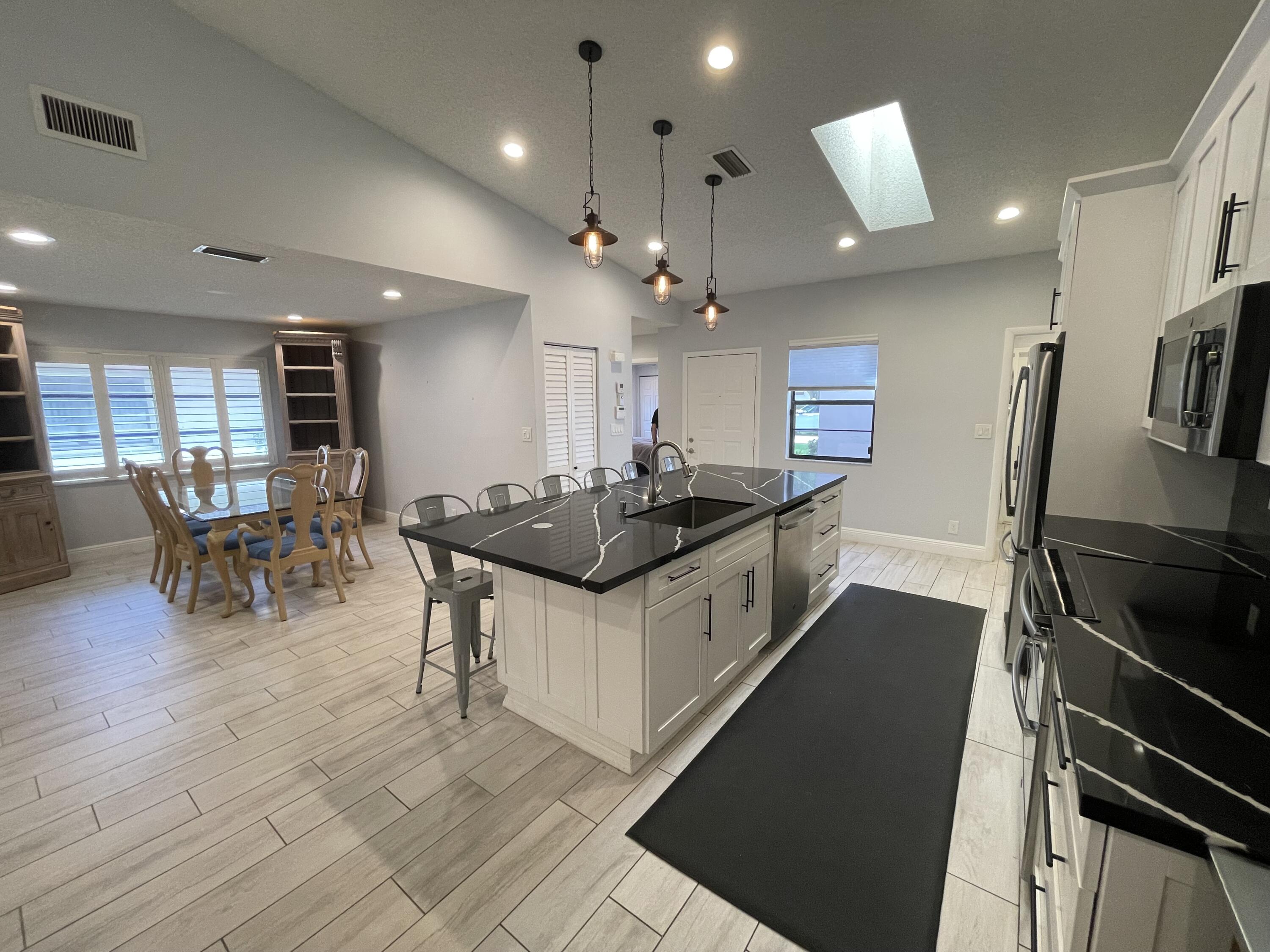 6157 Sunny Pointe Circle Delray Beach, FL 33484 - Photo 6 of 64 a kitchen with stainless steel appliances granite countertop a sink a stove and a refrigerator